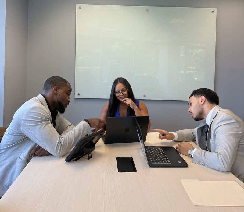 New Acquisitions brand representatives reviewing a partner campaign together in the Atlanta office conference room
